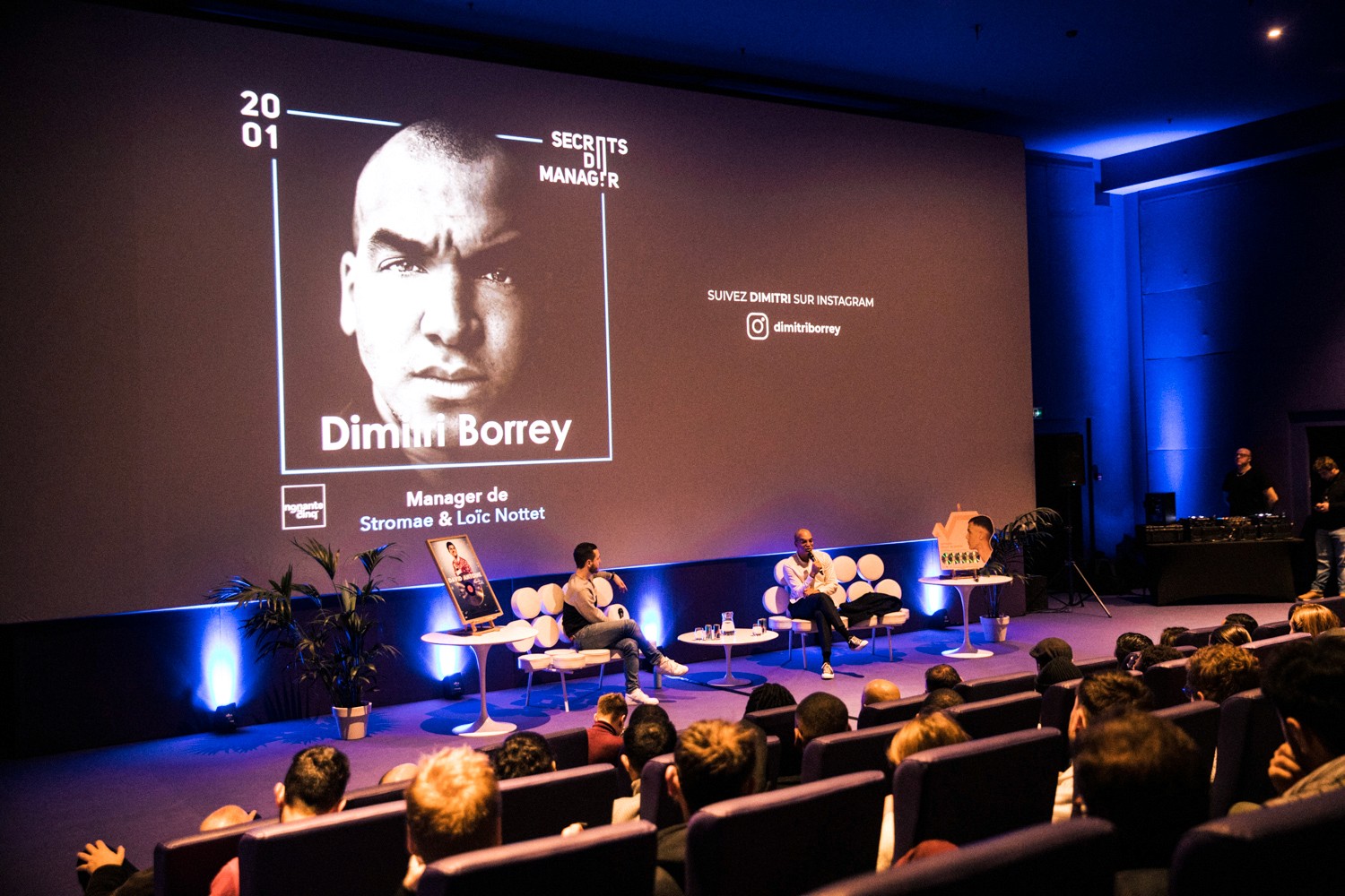 Modern home office setup with a monitor, ergonomic chair, keyboard, and indoor plants near a window with blinds.