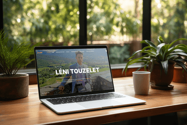 Mockup du site web de Léni Touzelet sur ordinateur portable, montrant une photo en costume sur un paysage verdoyant avec le nom en titre principal.