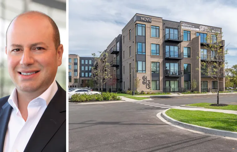 Tall modern skyscraper with vertical lines, viewed against a clear blue sky.