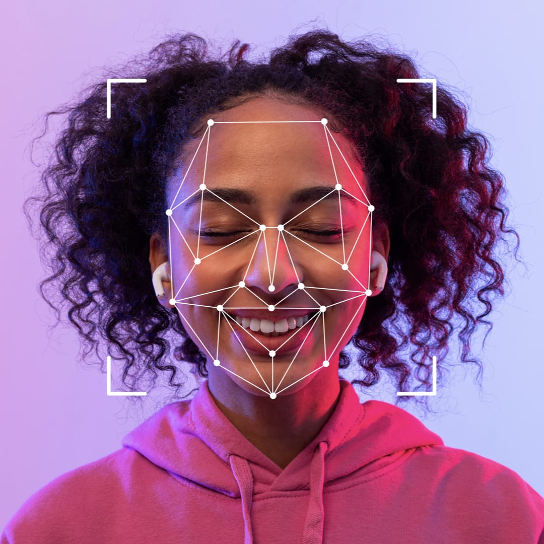 A close-up photo of  young woman with lines and dots representing key parts of her face suggesting facial recognition technology