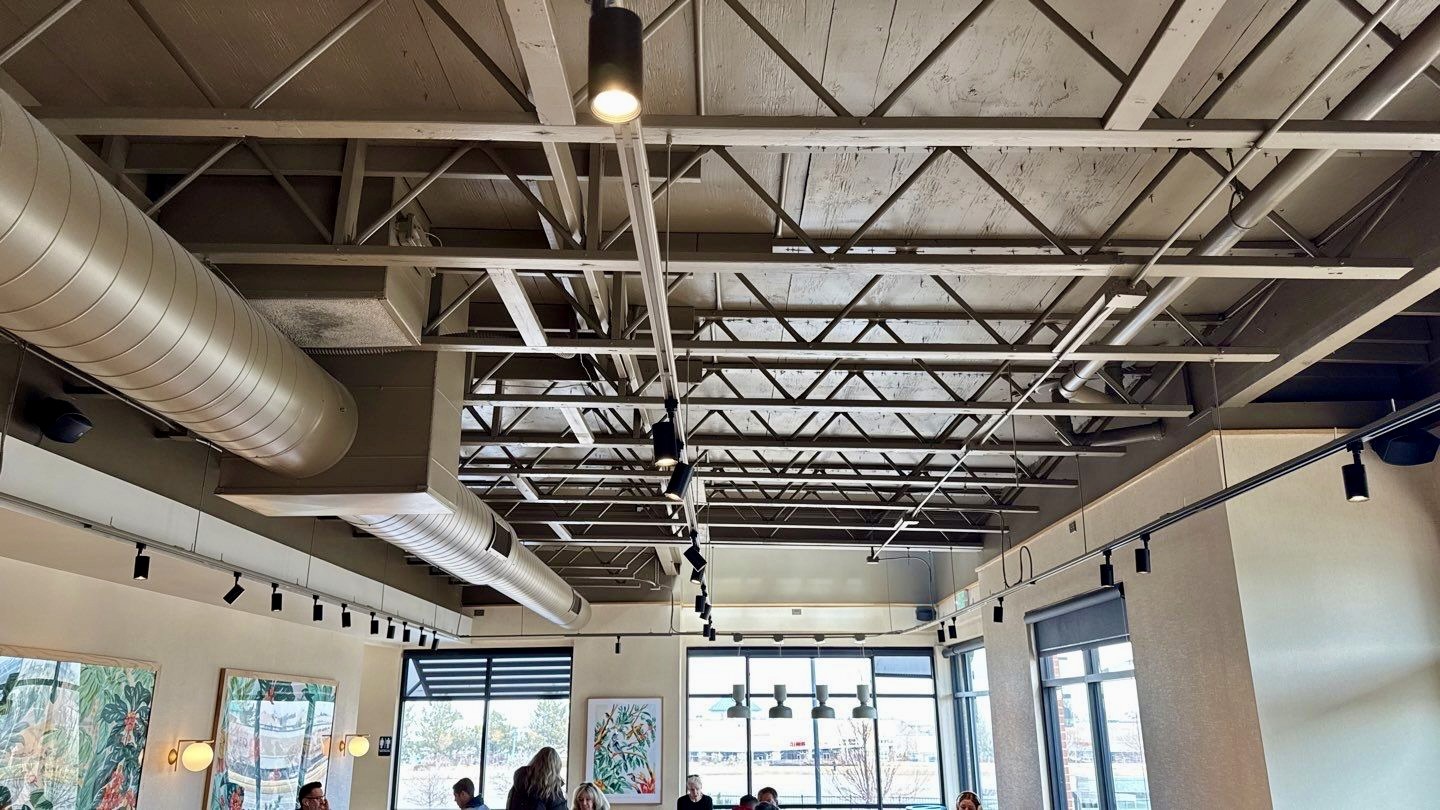 Spotless exposed ceiling beams and ducts after cleaning, enhancing the open ceiling design.