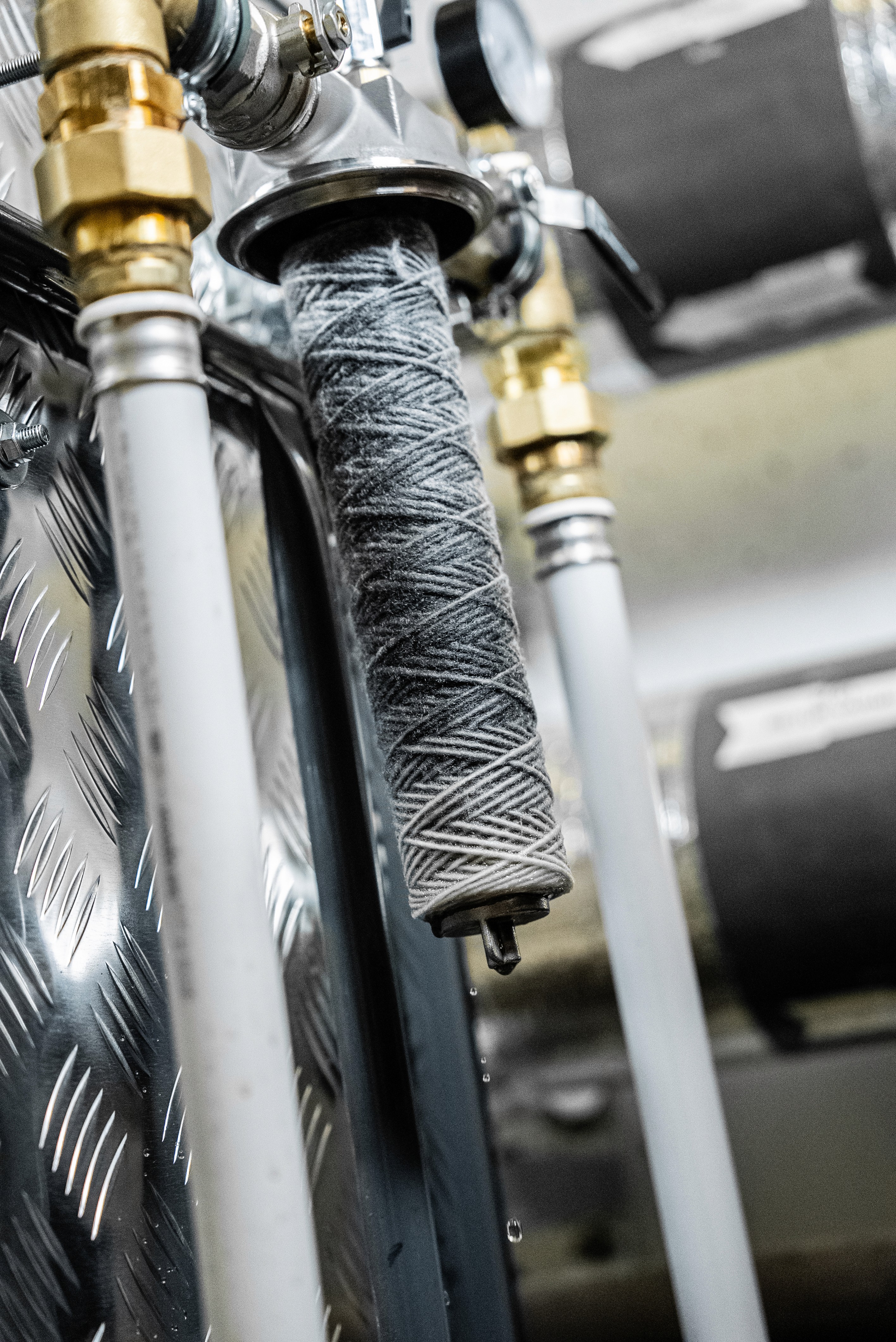Two women, one in a hijab, looking happily at a tablet on a speckled table in a cafe.