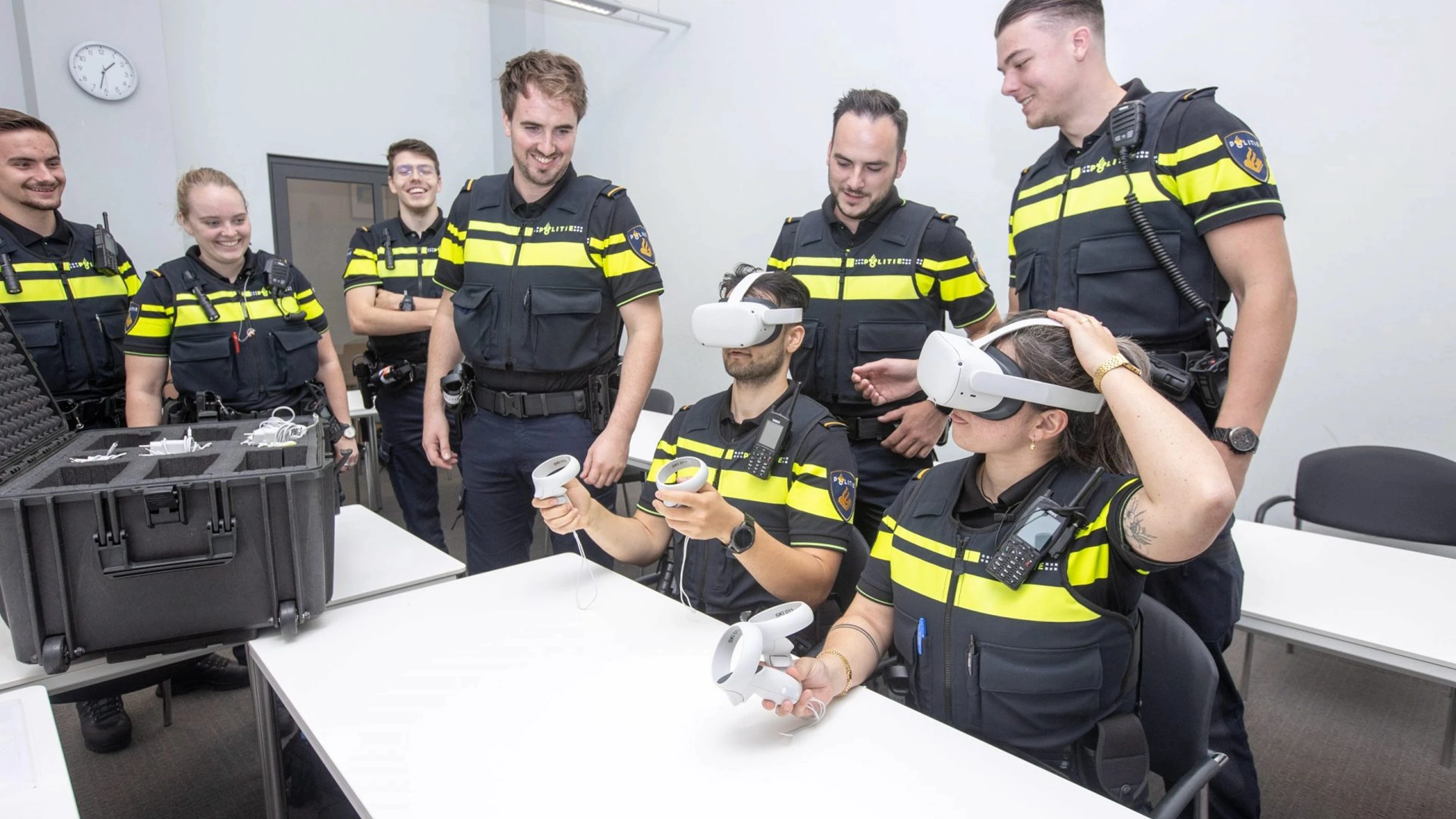 Police officers being fitted with VR headsets and controllers during a training session