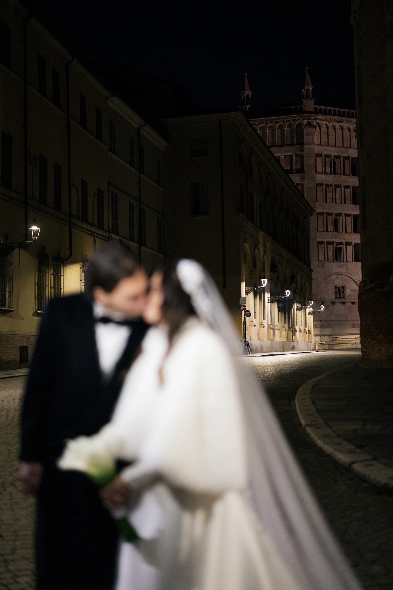 Sposi in abito da cerimonia davanti al Circolo di Lettura di Parma, scatto notturno con architettura sullo sfondo