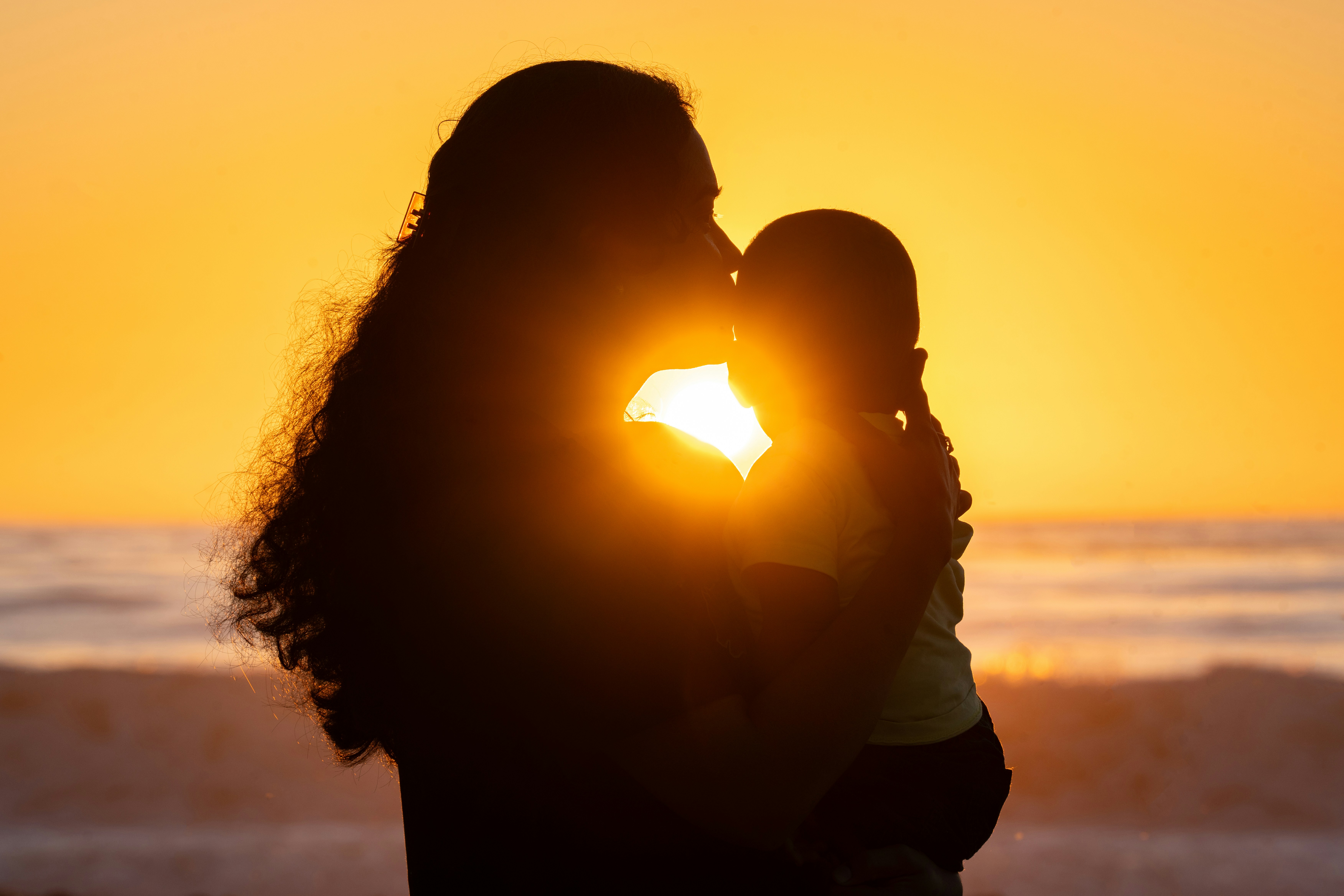 A couple kissing on the beach at sunset