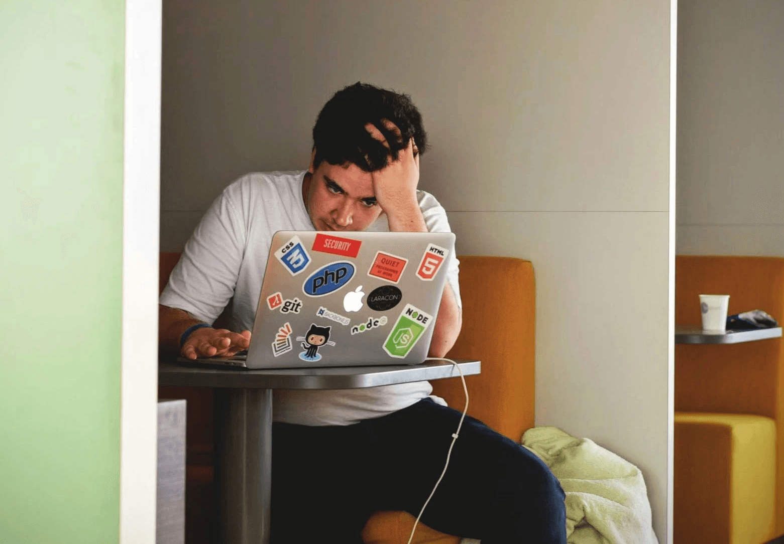man wearing white top using MacBook