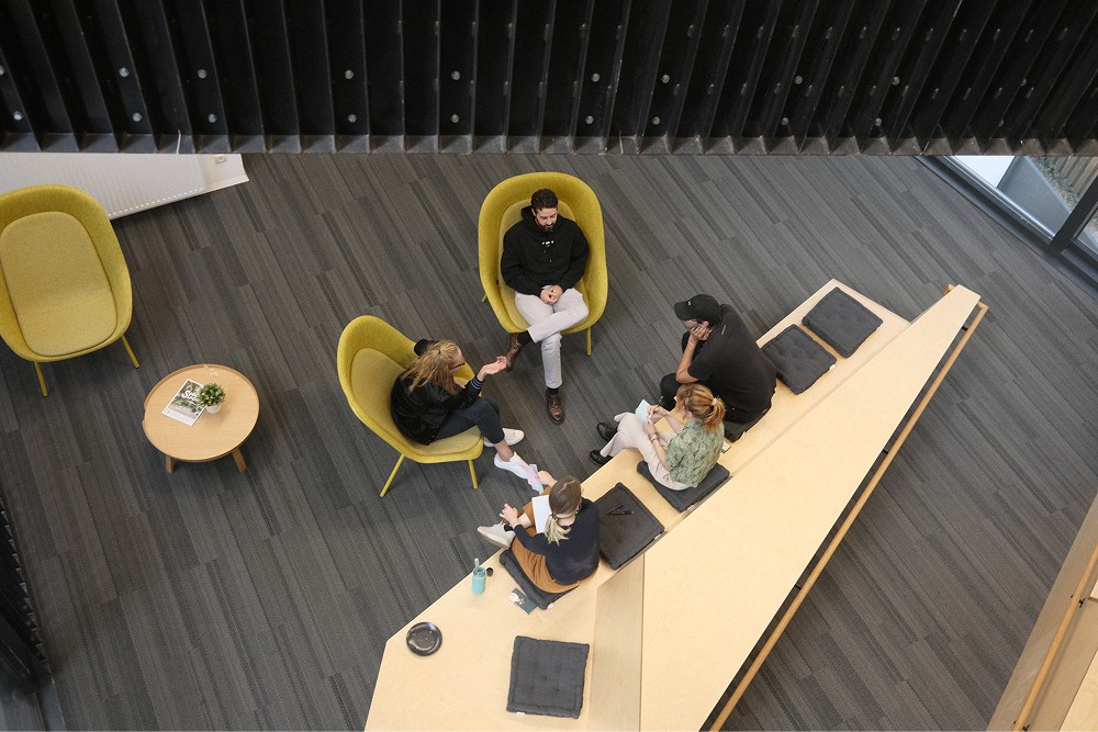 Teammeeting in einem modernen, offenen Arbeitsbereich.