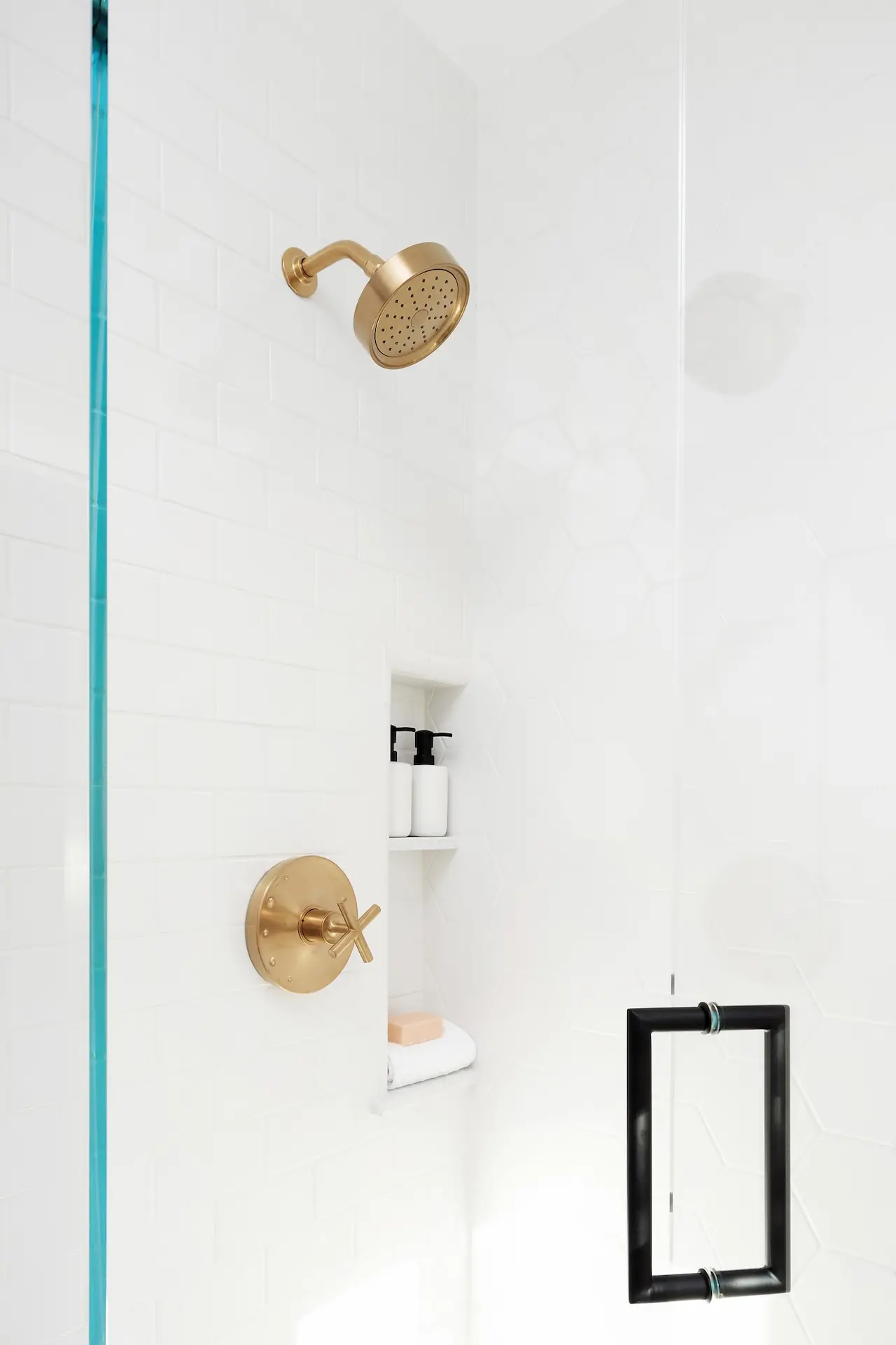 Minimalist shower detail with brass fixtures and sleek glass partition in the North Tustin Remodel & Addition. Photo by Molly Rose.