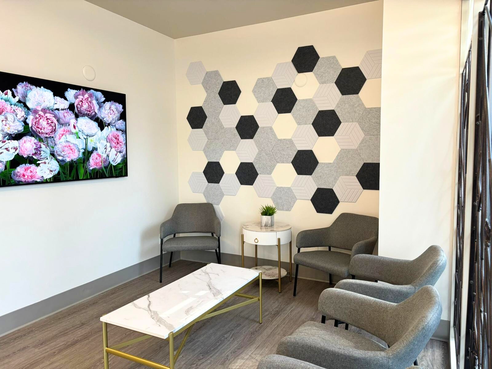 A cozy waiting area at Metro Pointe Dental featuring comfortable chairs, a small table, and decorative wall art, creating a welcoming atmosphere for patients