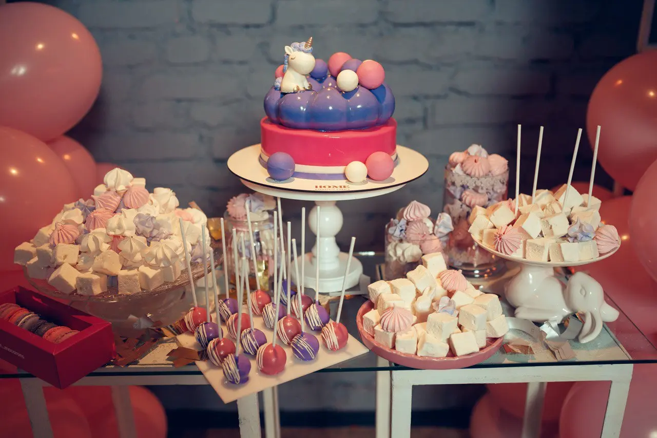Elaborate dessert table with tiered celebration cake, cake pops, and assorted sweet treats