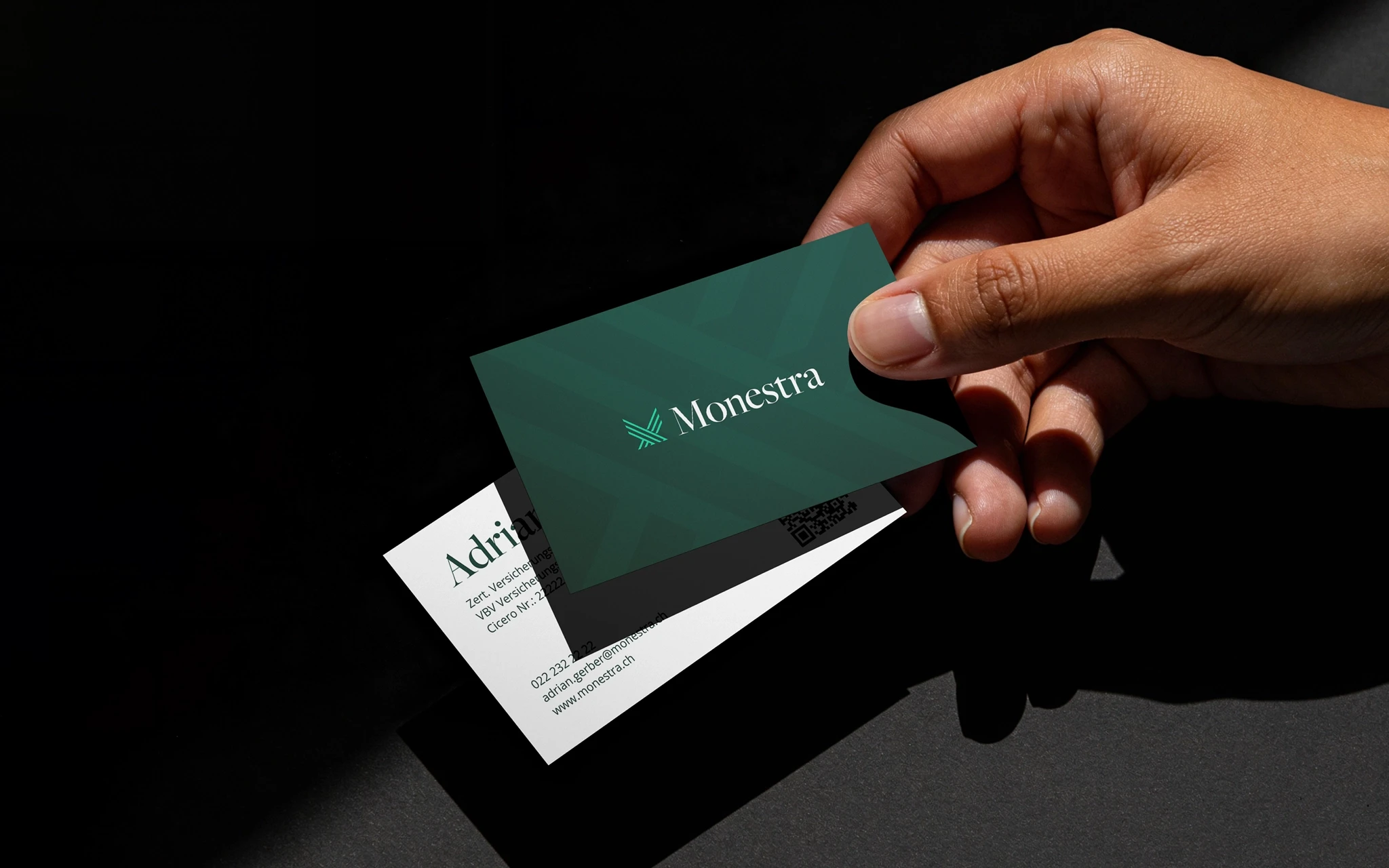 Mão a segurar um cartão de visita Monestra verde-escuro