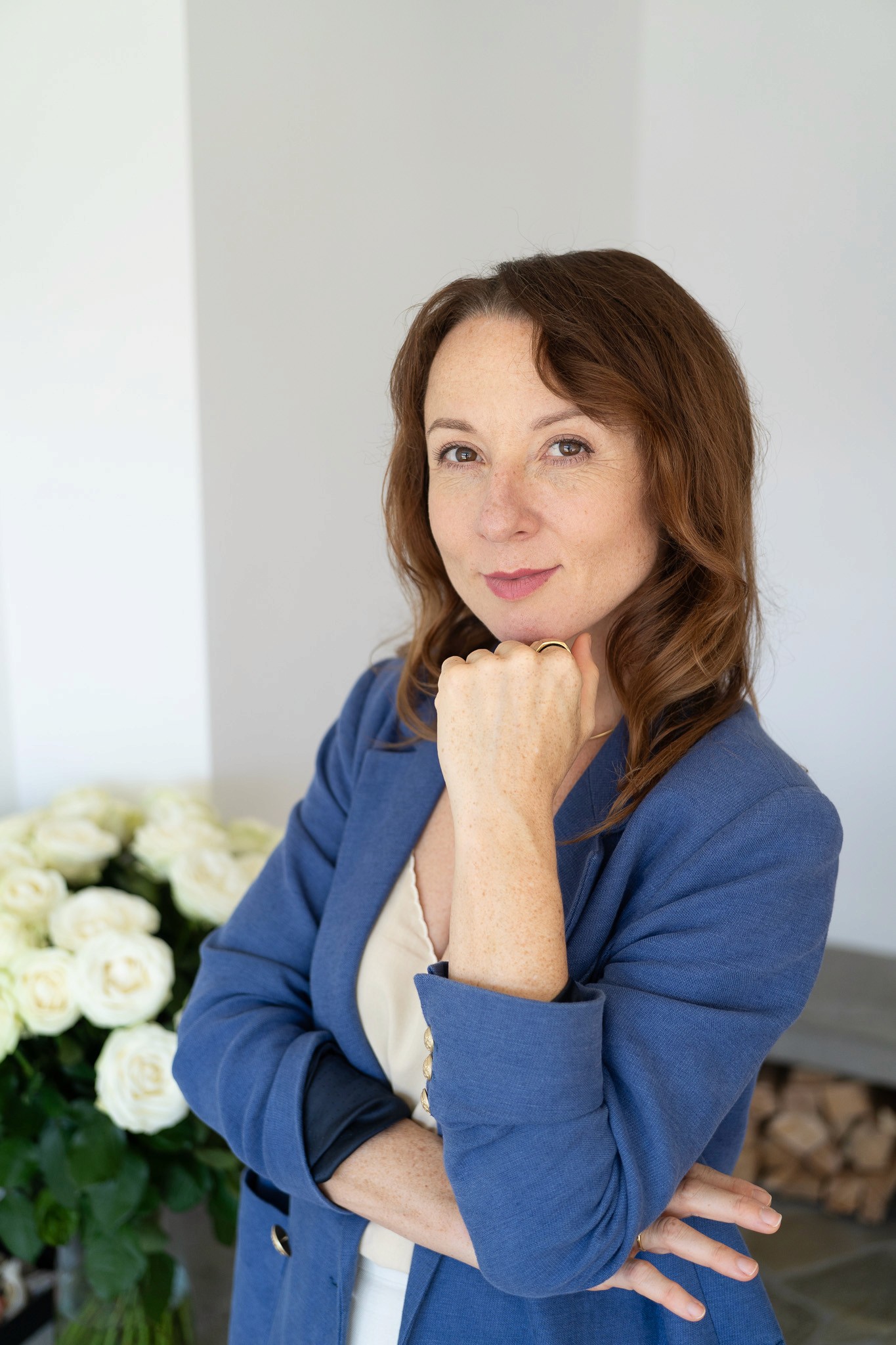 Man and woman standing together at a desk with a laptop and notebooks, smiling at the camera.