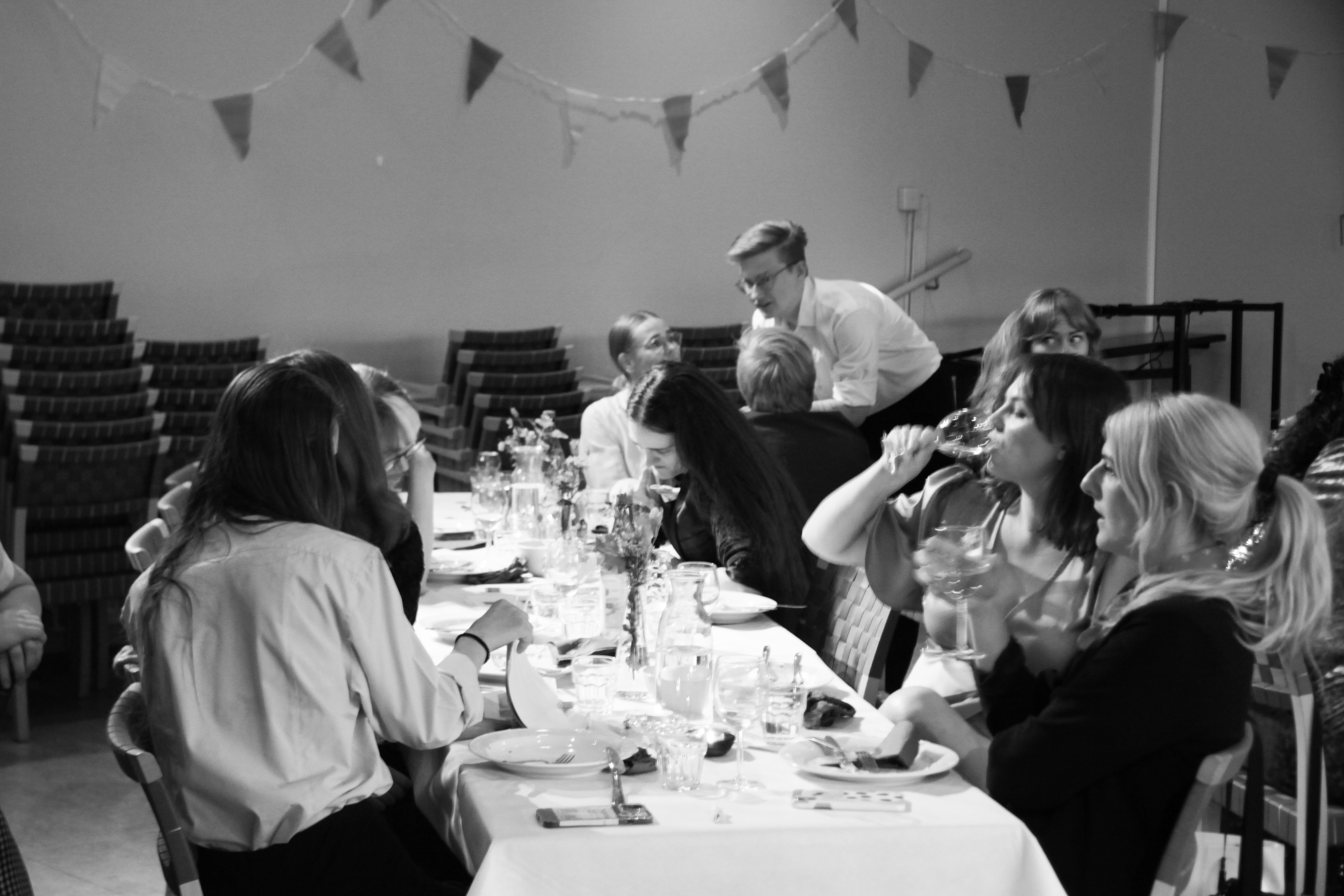 A group of people chatting at a dining table.