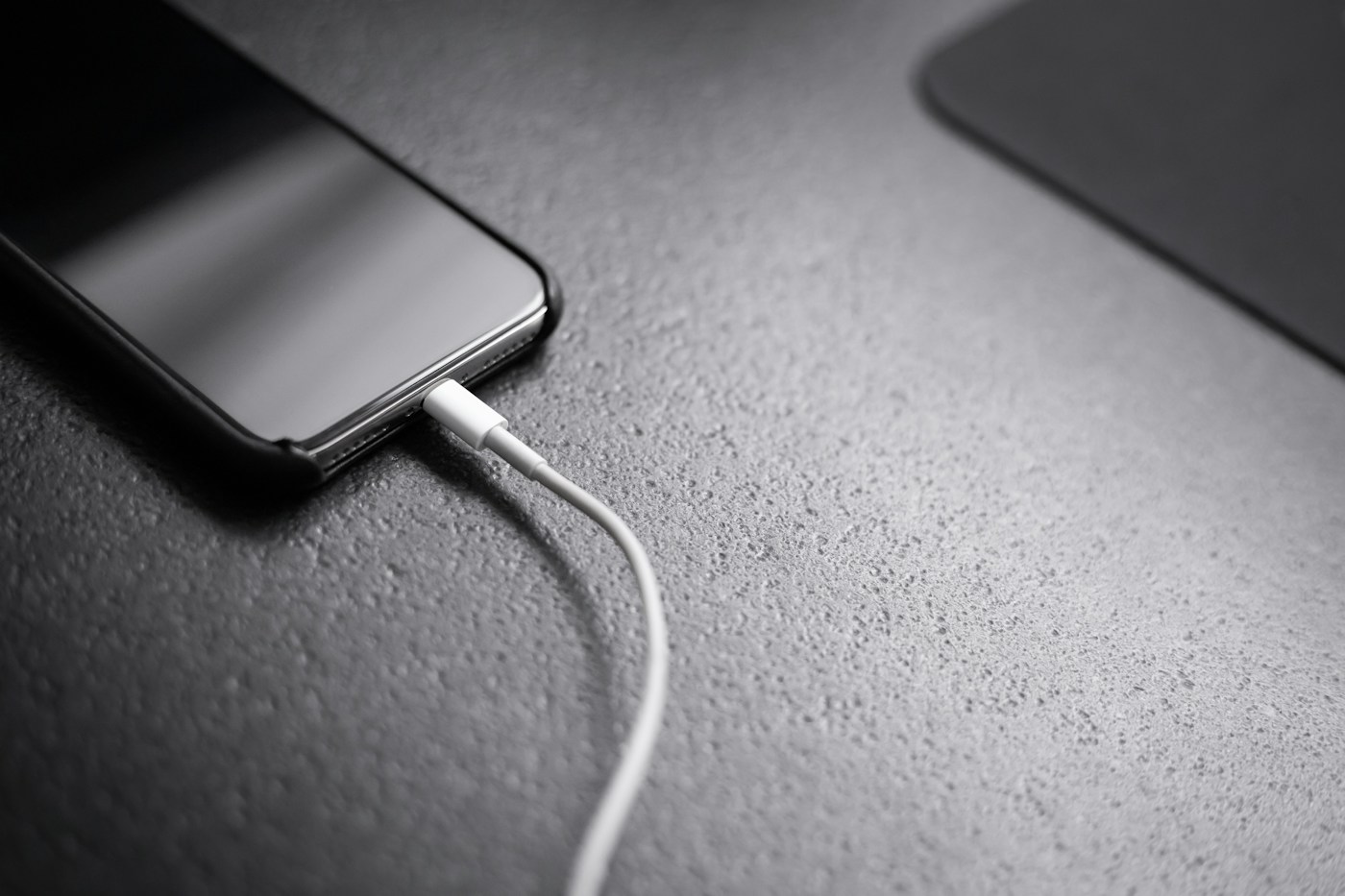 Black smartphone with charger cord connected
