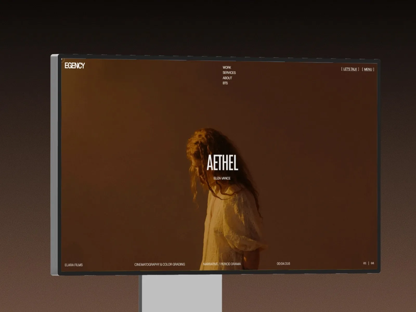 Monitor displaying a website with "Aethel" and a woman in warm lighting.