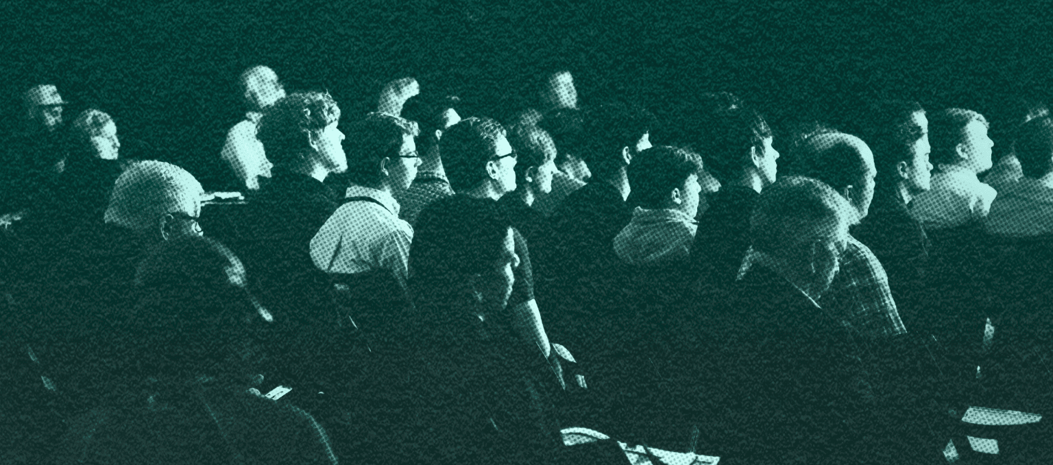 Audience seated at a marketing conference, listening to a speaker, representing industry events and professional networking in email marketing.