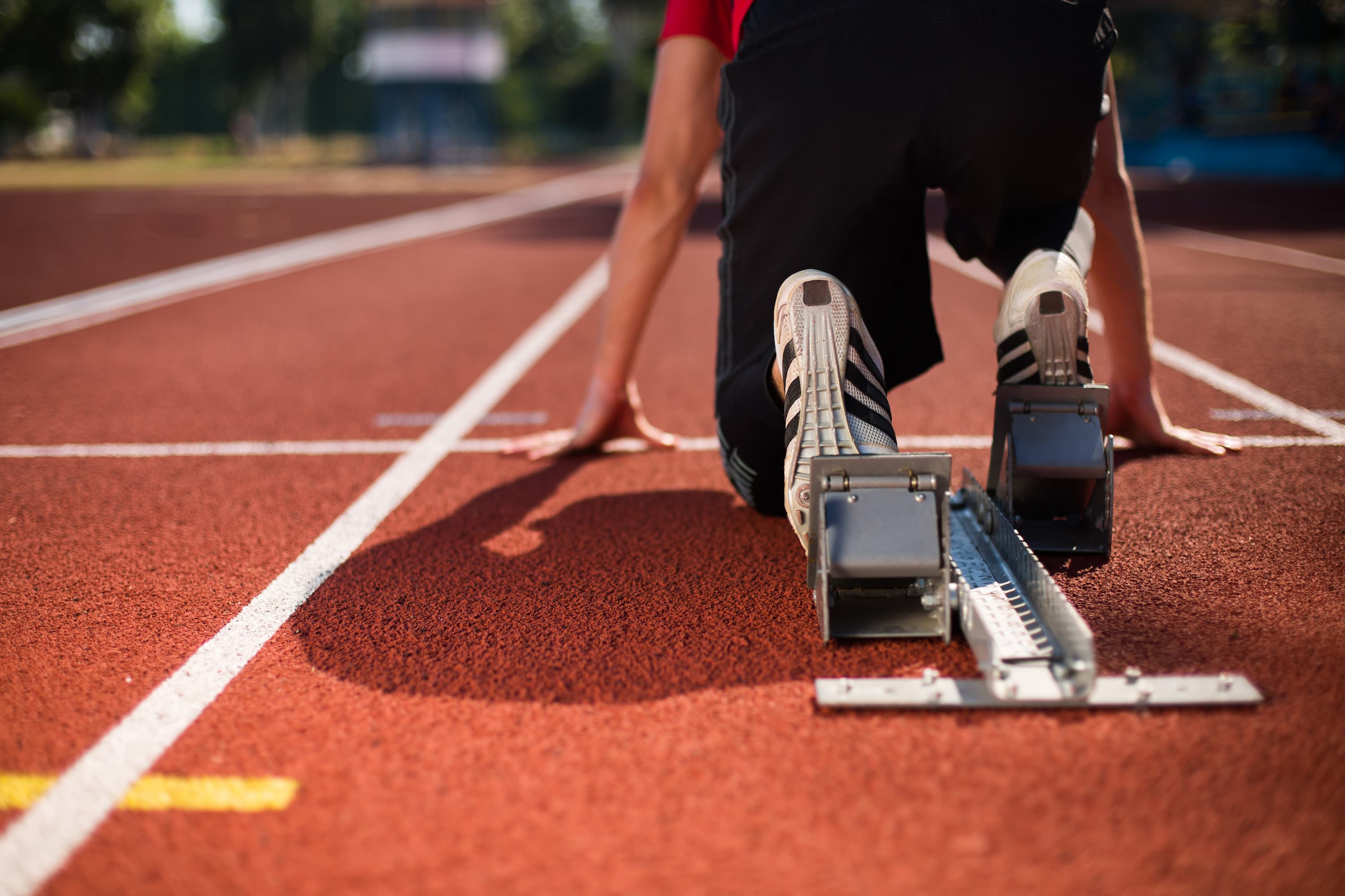 Close-up from behind of running shoes at the starting line before a race.