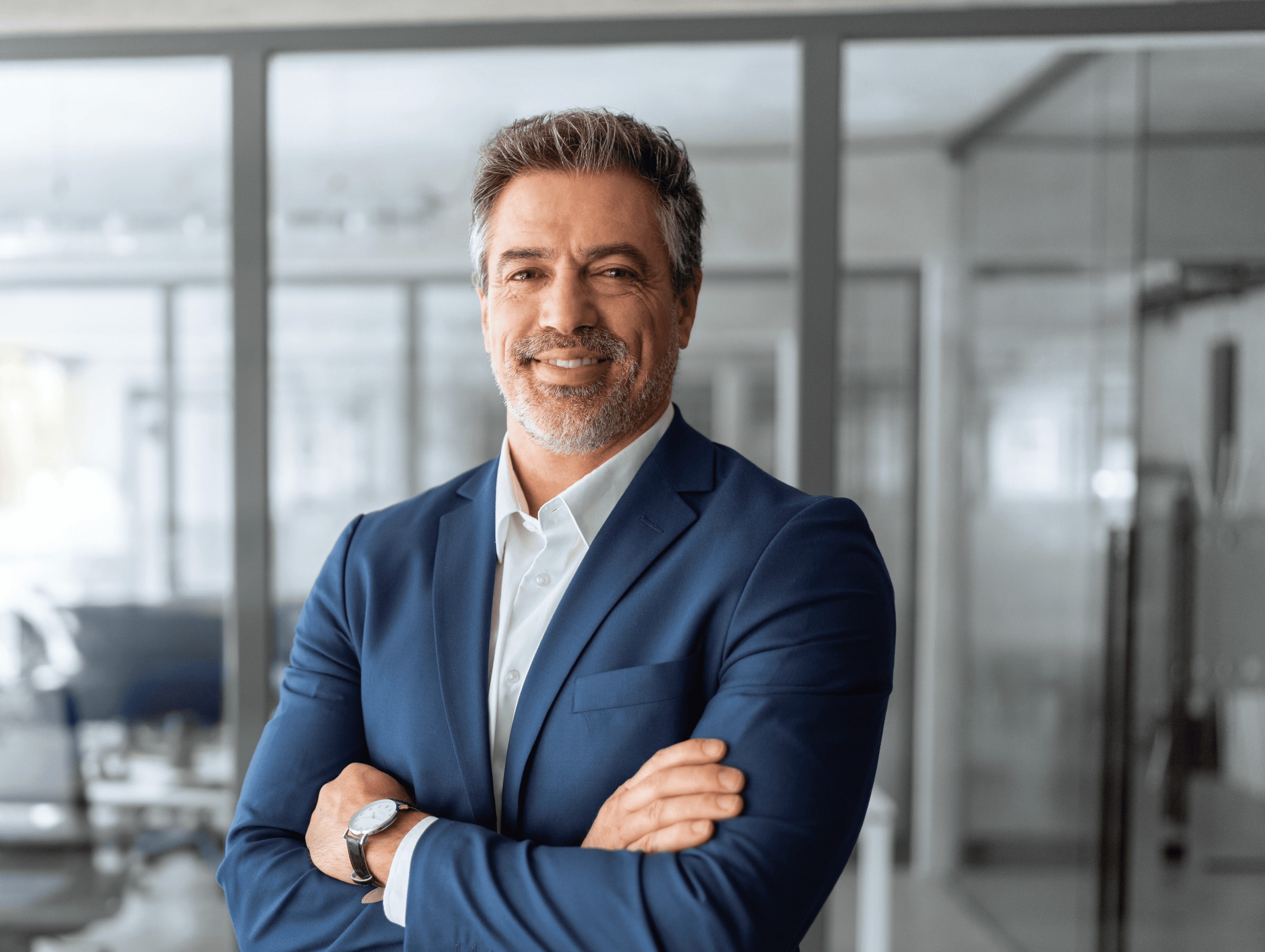 A person with curly hair and glasses, wearing an orange sweater, looks thoughtfully into the distance, resting their chin on their hand. Warm, cozy ambiance