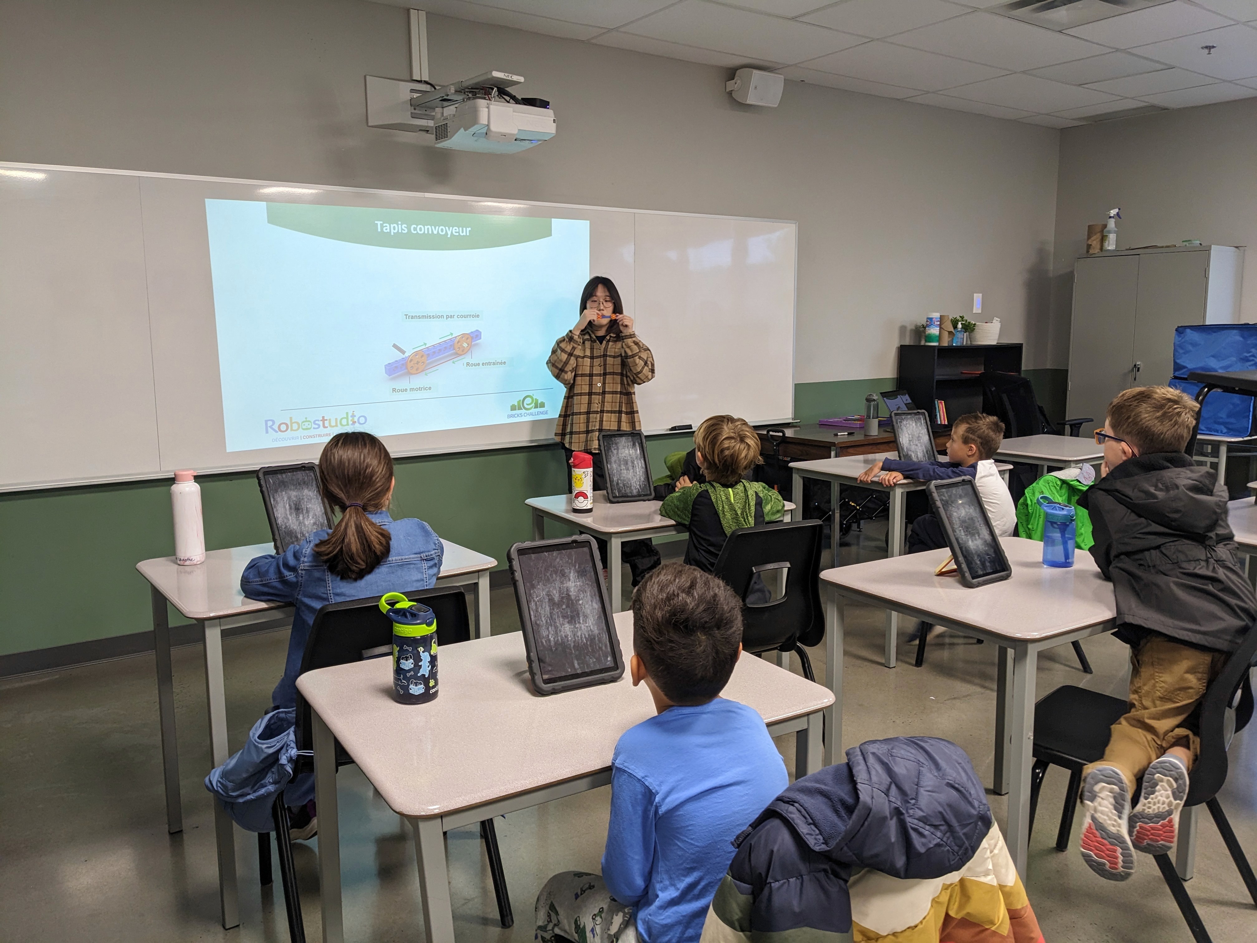 Enfant concentré assemblant un robot avec des blocs LEGO lors d’un atelier Young Engineers à Montréal.
