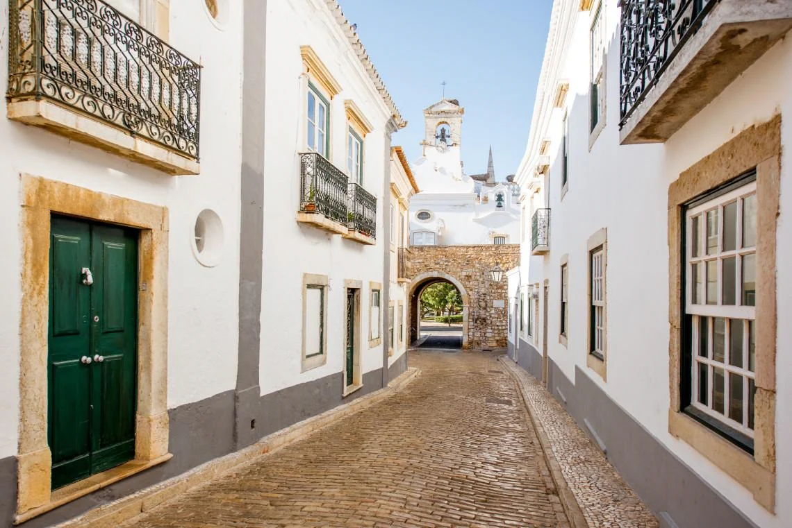 Cobbled street and historic arch in Faro Old Town.