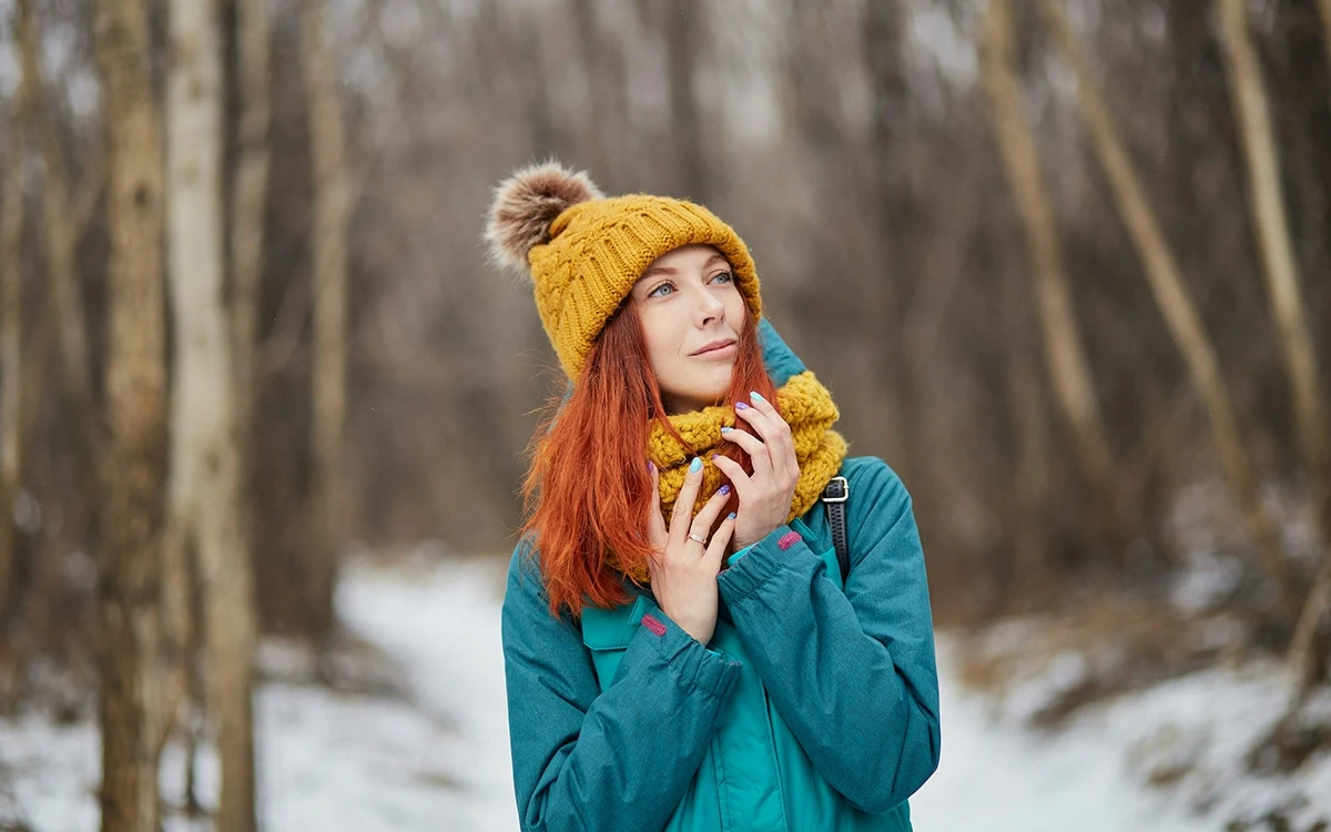 Woman in a winter hat and scarf outdoors in the cold