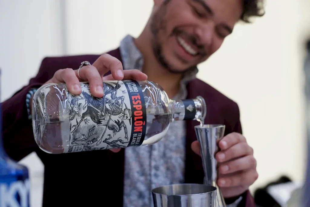 Bartender pouring a bottle of tequila
