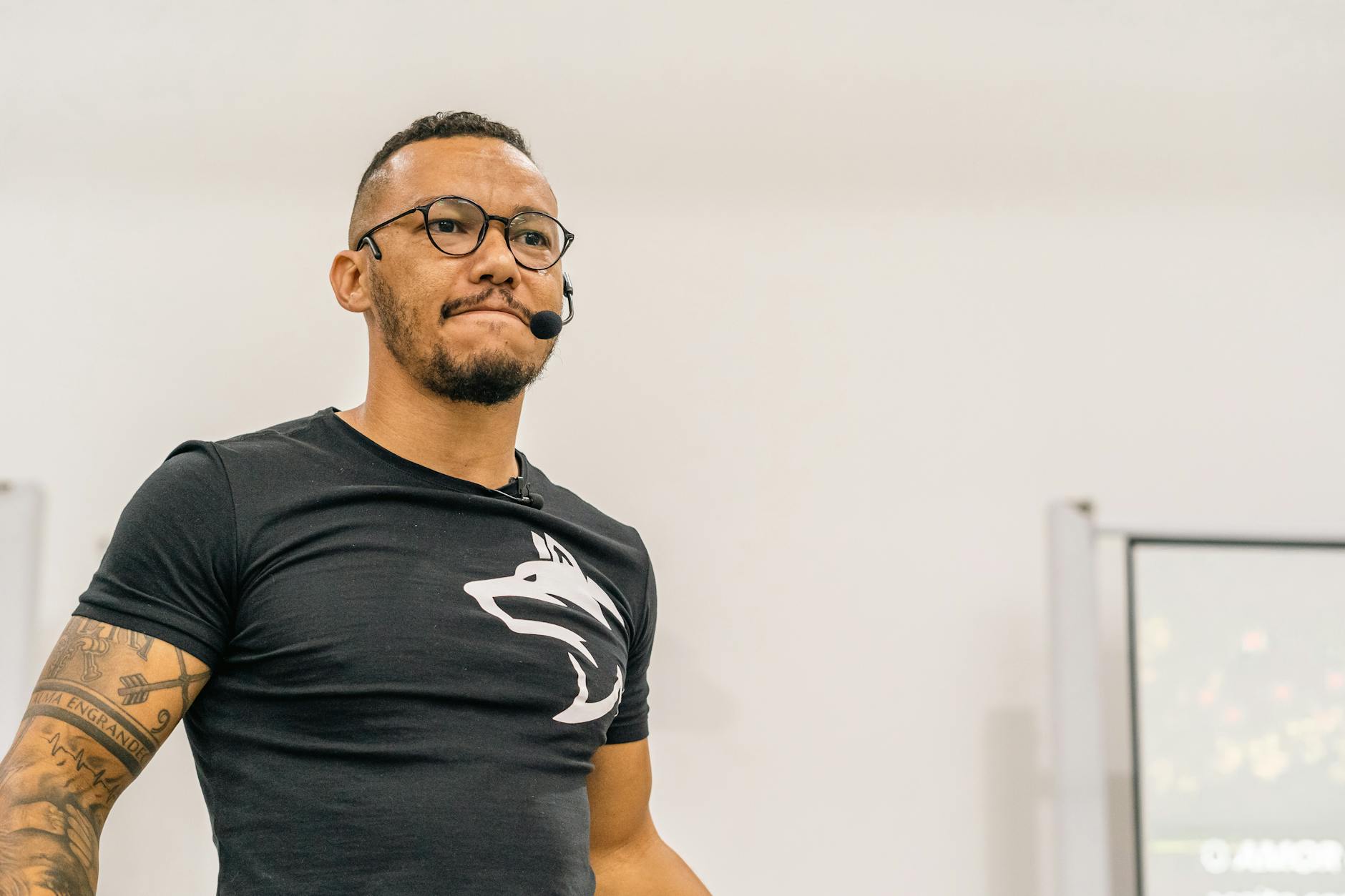 A teacher standing at a whiteboard drawing a monthly schedule for new classroom listening activities.