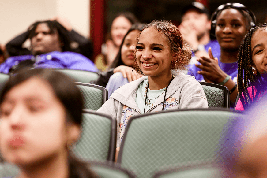 Highschool student smiling at PEF's camp college talent show, representing PEF's community-building efforts.