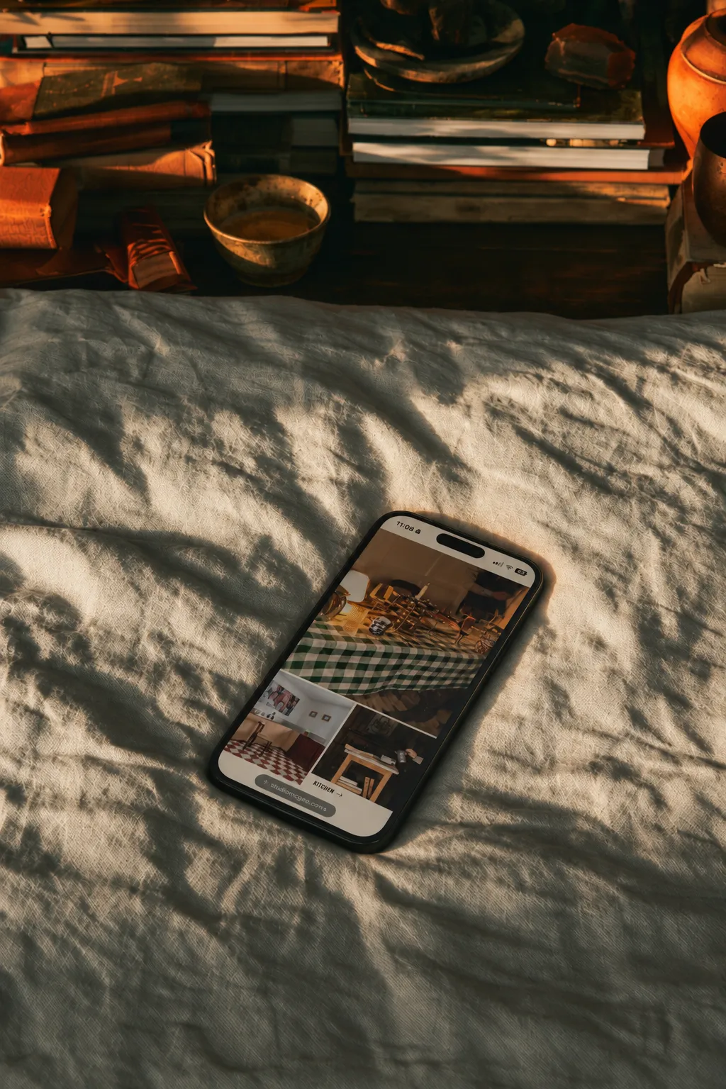 Nicole’s Lantgård mobile website displayed on a smartphone resting on linen bedding in warm natural light.