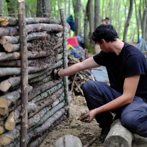 Percorso di sopravvivenza e bushcraft per adulti: costruzione di strutture in legno durante un’esperienza di educazione indigeno-primitiva in natura