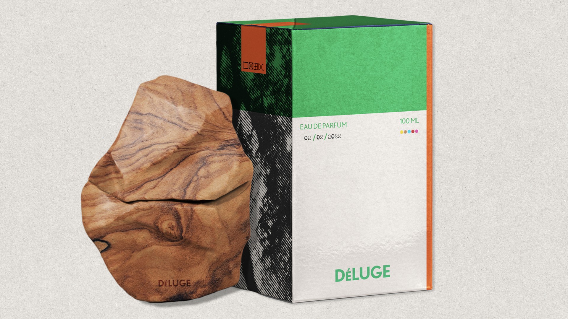 A light brown wooden object with a rough, irregular texture sits beside a rectangular box. The box is primarily white with green and orange accents and features the text "DÉLUGE" in green at the bottom right corner. The box also displays "EAU DE PARFUM" and "100 ML" along with a date, "02/02/2022", printed on it. The background is a light gray textured surface.