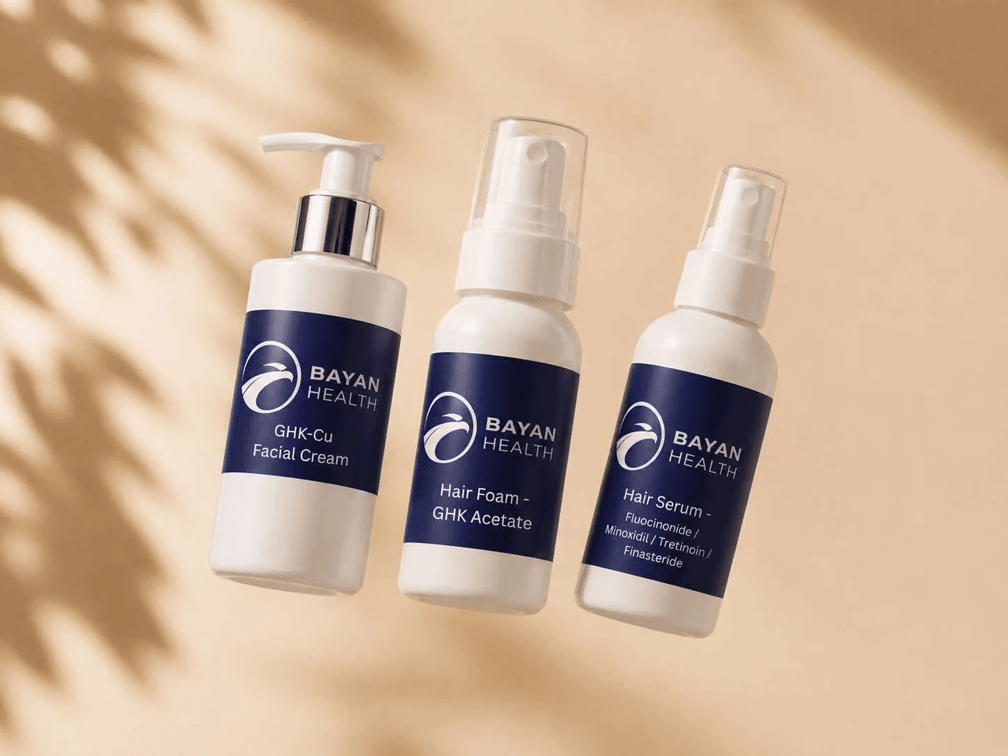 Bayan Health GHK-Cu facial cream, hair foam, and hair serum bottles displayed against a beige background.