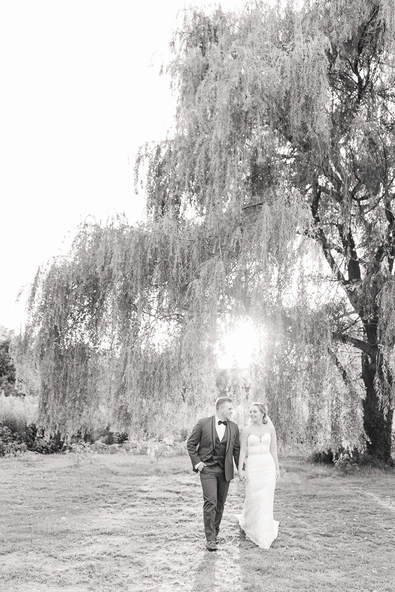 Bride and groom Nashville Tennessee wedding portrait under willow tree during sunset on golf course.