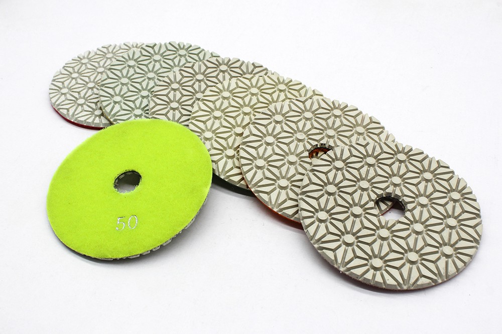 Resin bond diamond polishing pads with a flower-like pattern, arranged in a fan shape.