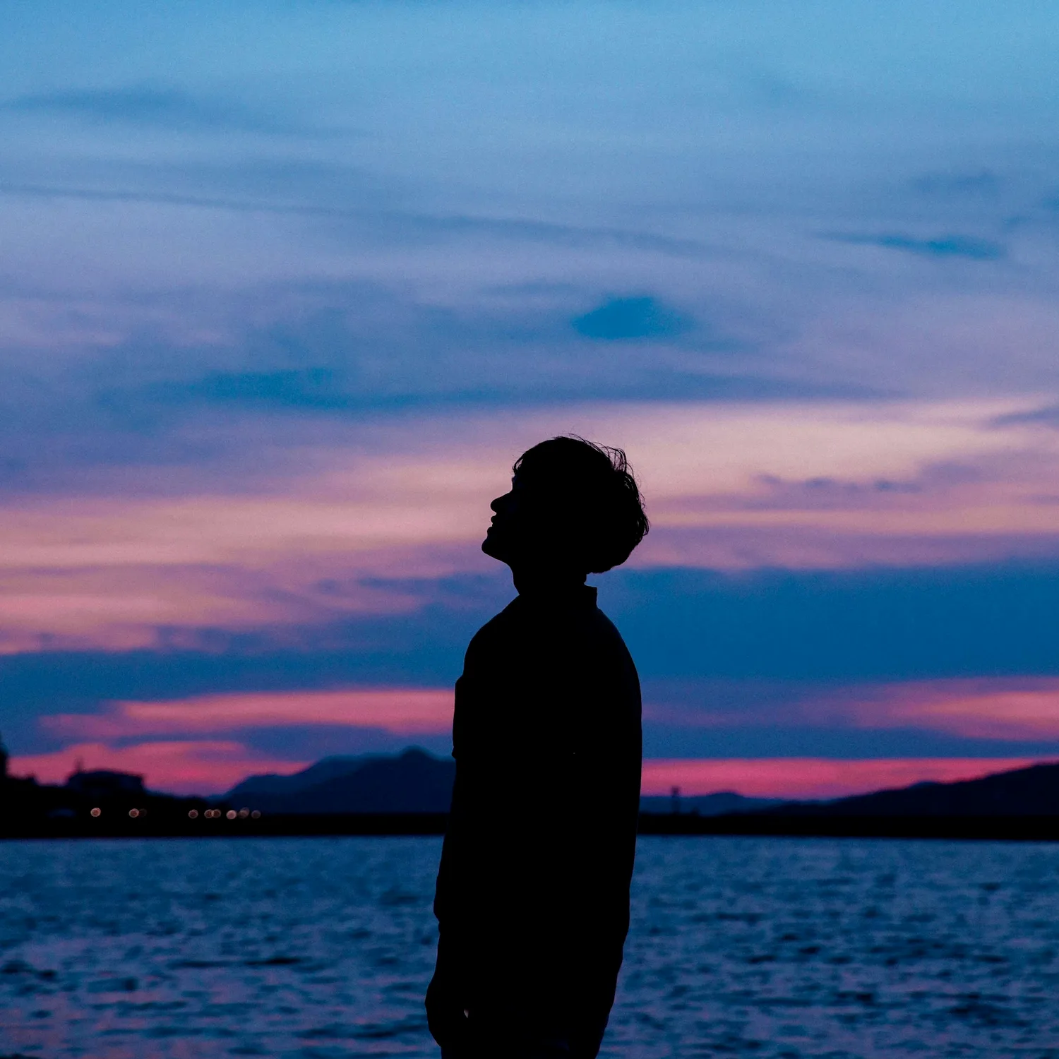 Silhouette of a person reflecting at sunset, symbolizing healing and self-discovery through online therapy in New York City.