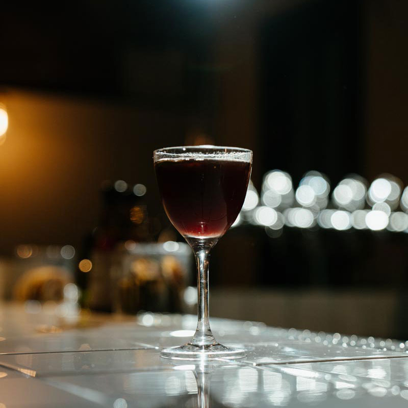 Dark and moody shot of a cocktail sitting on a bar