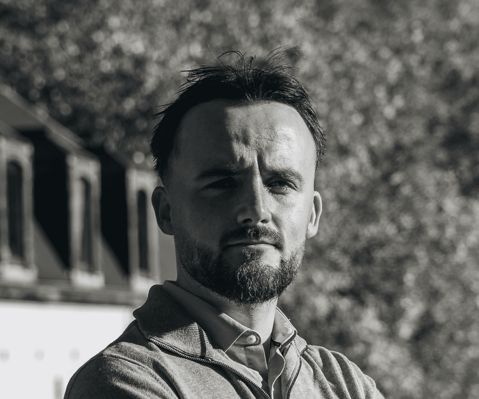Portrait of a laughing person with curly hair wearing a white shirt