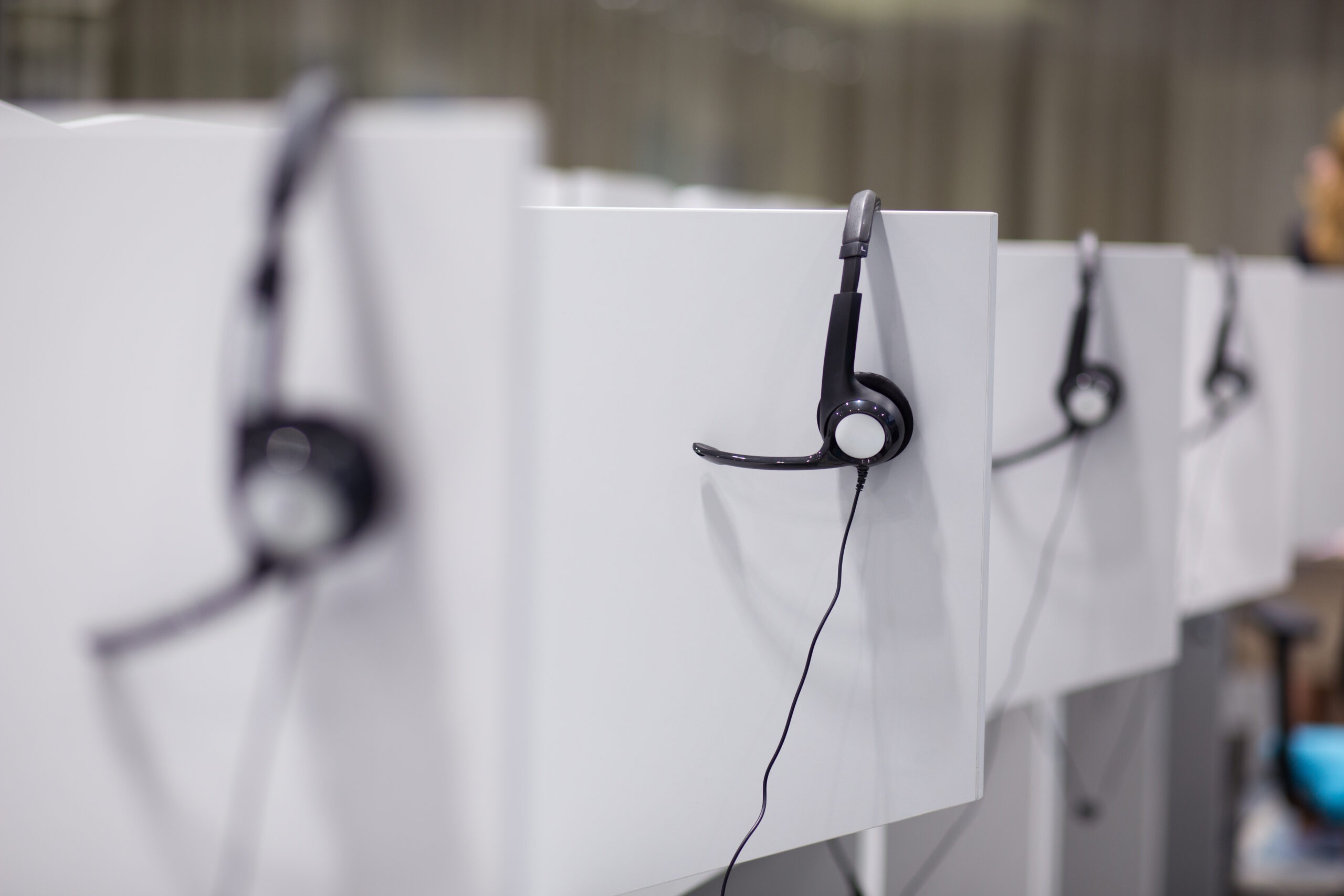 Headphones hanging on cubicle partition in empty call center office