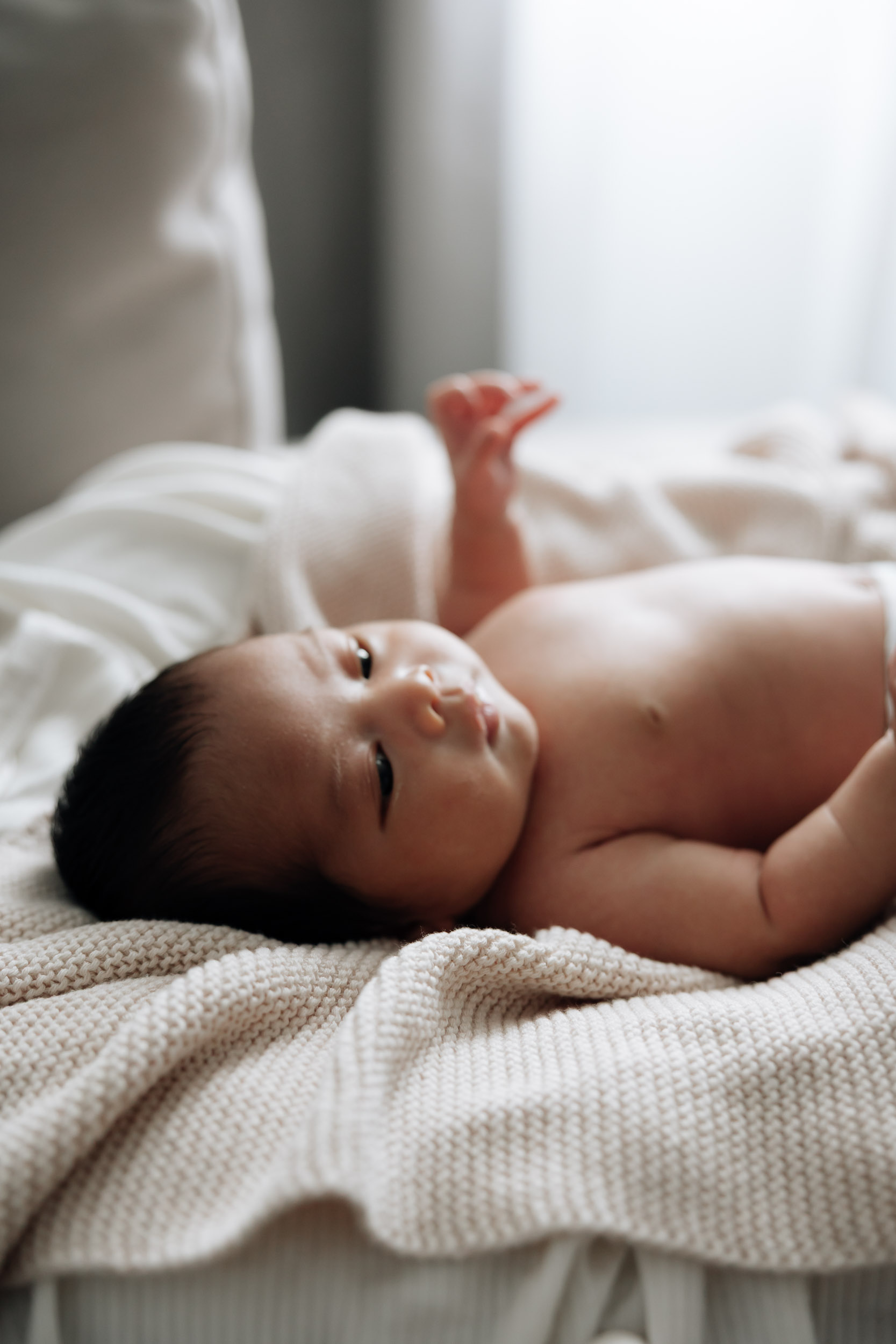 Newborn baby laying down near a window
