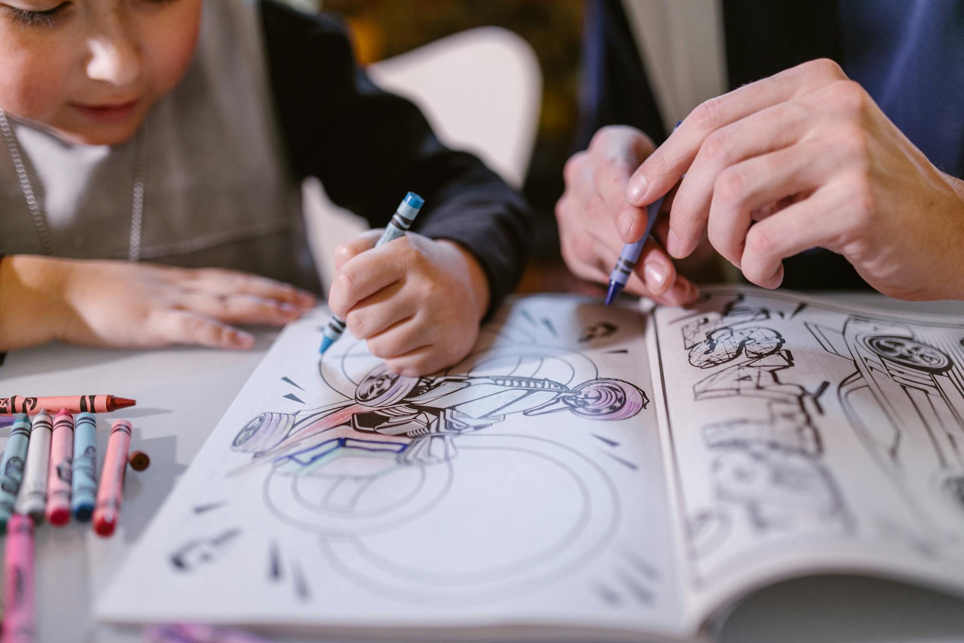 A child's hands using a bright yellow pencil to solve a complex maze in a colorful activity book on a wooden desk.