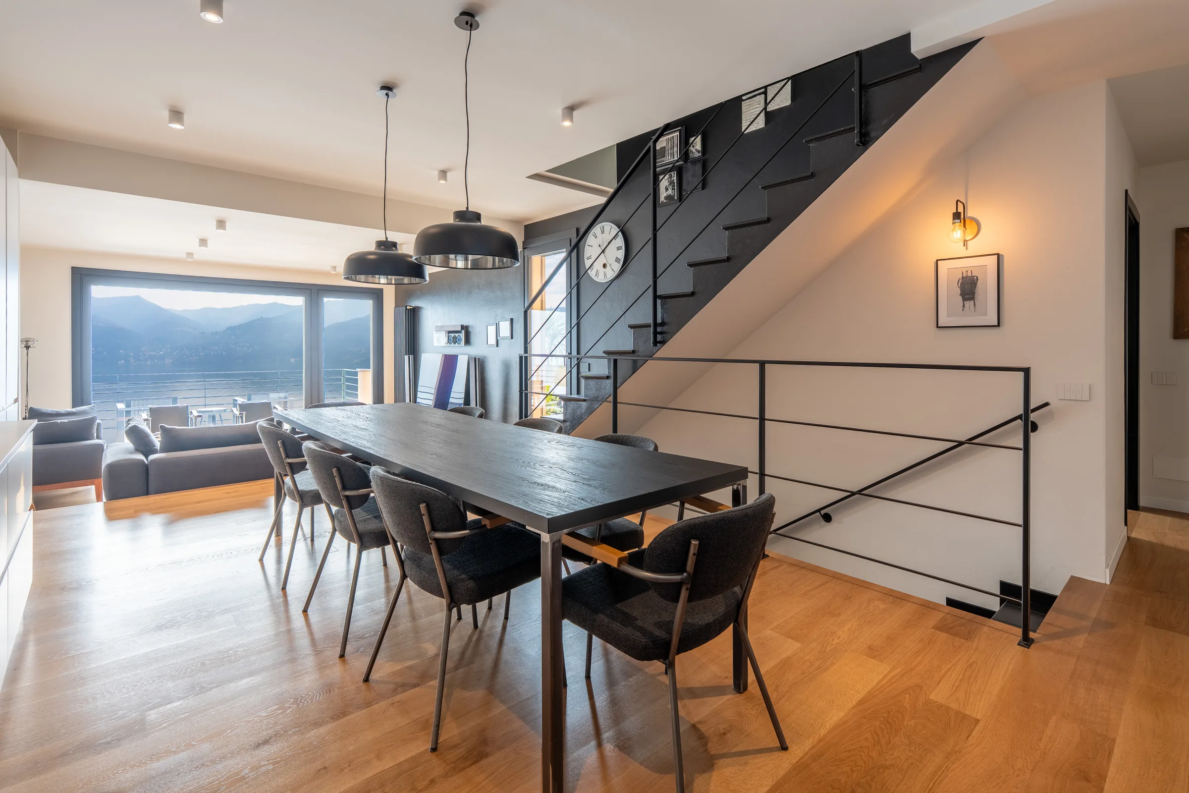 Wooden staircase and dining room with lake views — Lake Como, Italy. Photography by Yunes Calore.