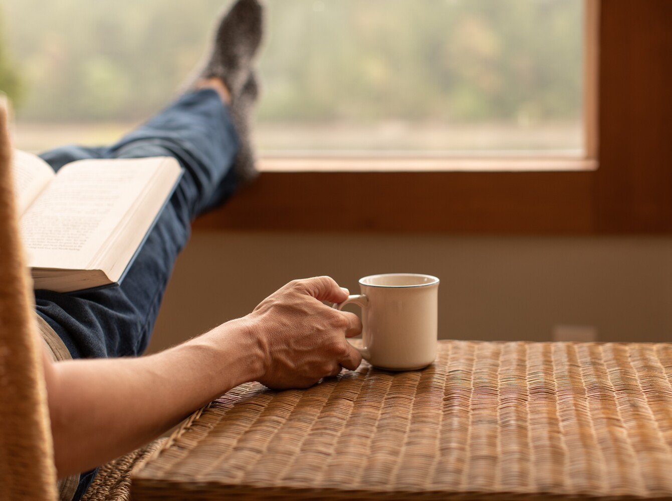 person relaxing at home with a book and tea to recover from their walking for weight loss plan