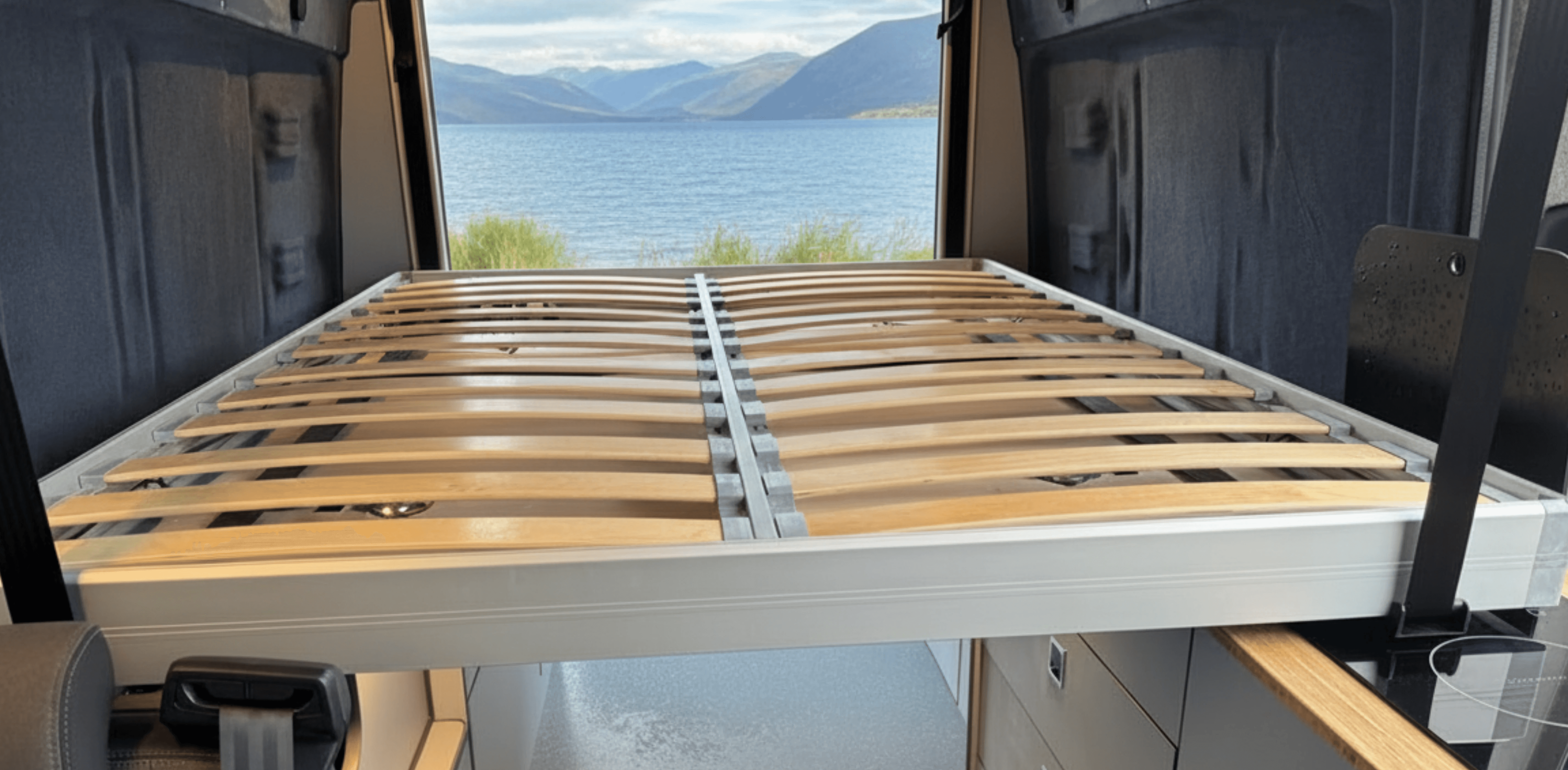bed without mattress in back of a campervan