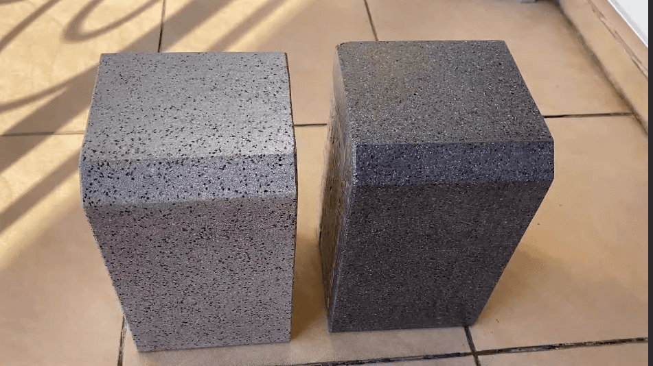 Two rectangular blocks made from foam ceramics, placed side by side. One block is light grey, and the other is dark grey, showing variations in color and texture.