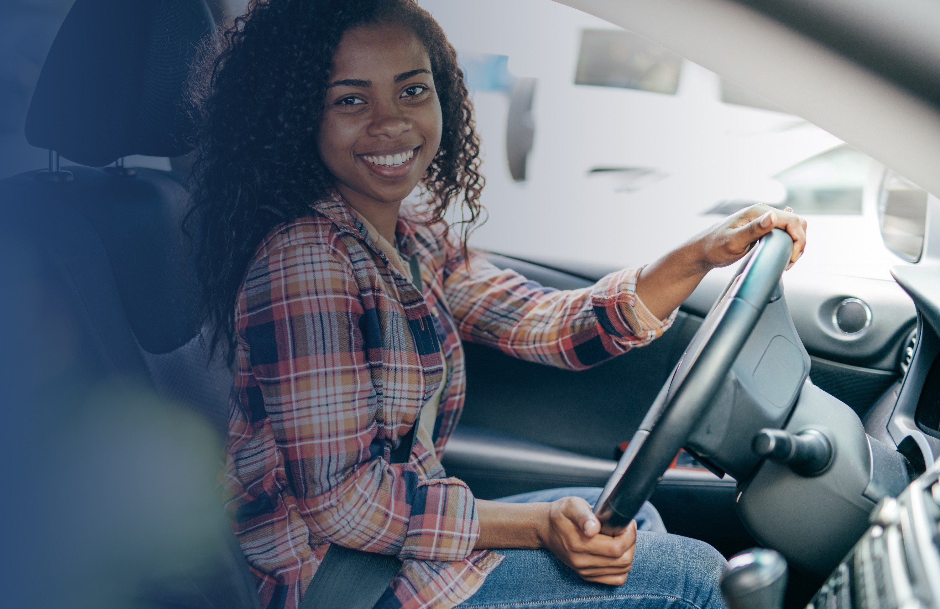 Woman placing a toddler into a car seat inside a car, representing safe driving for no claims bonus