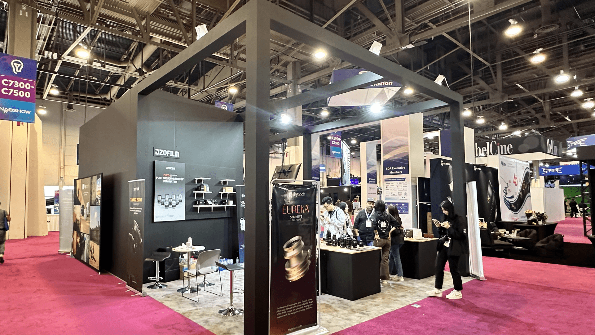 Dedicated "Thypoch" section with black walls and "Eureka" lens signage, creating a distinct zone within the booth.