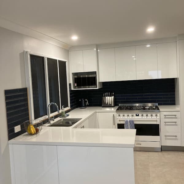 Modern kitchen renovation with white cabinets and modern appliances in Brisbane