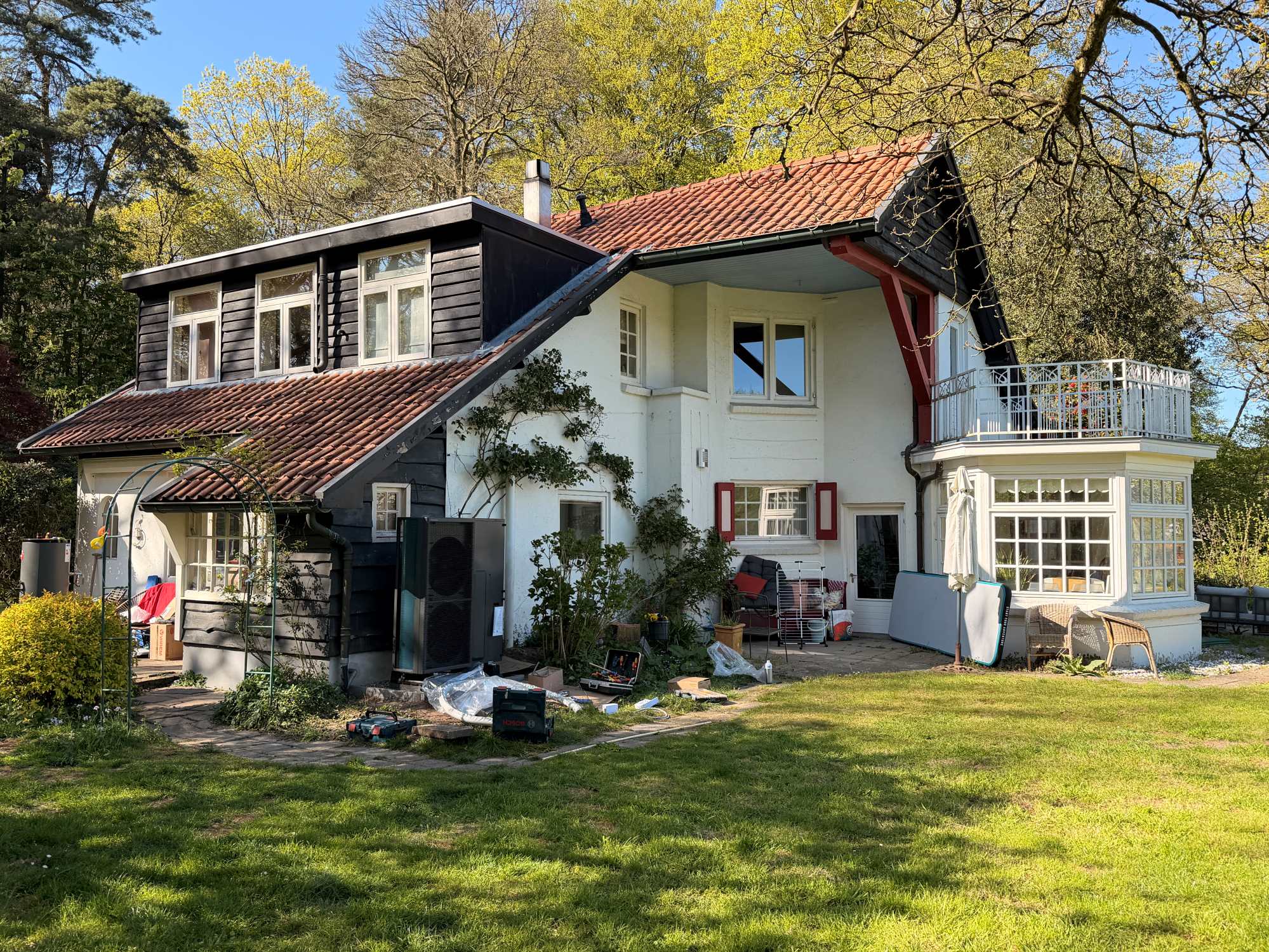 Buitenunit van een warmtepomp naast een jaren 30 woning