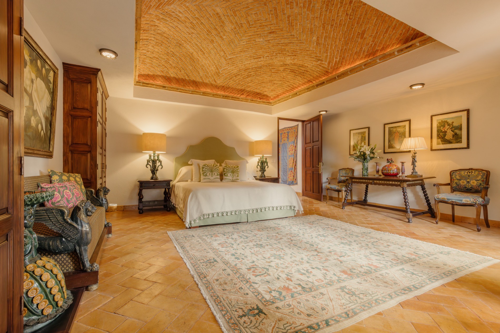 La Residencia guest bedroom with brick vaulted ceiling, king bed, and antique furnishings
