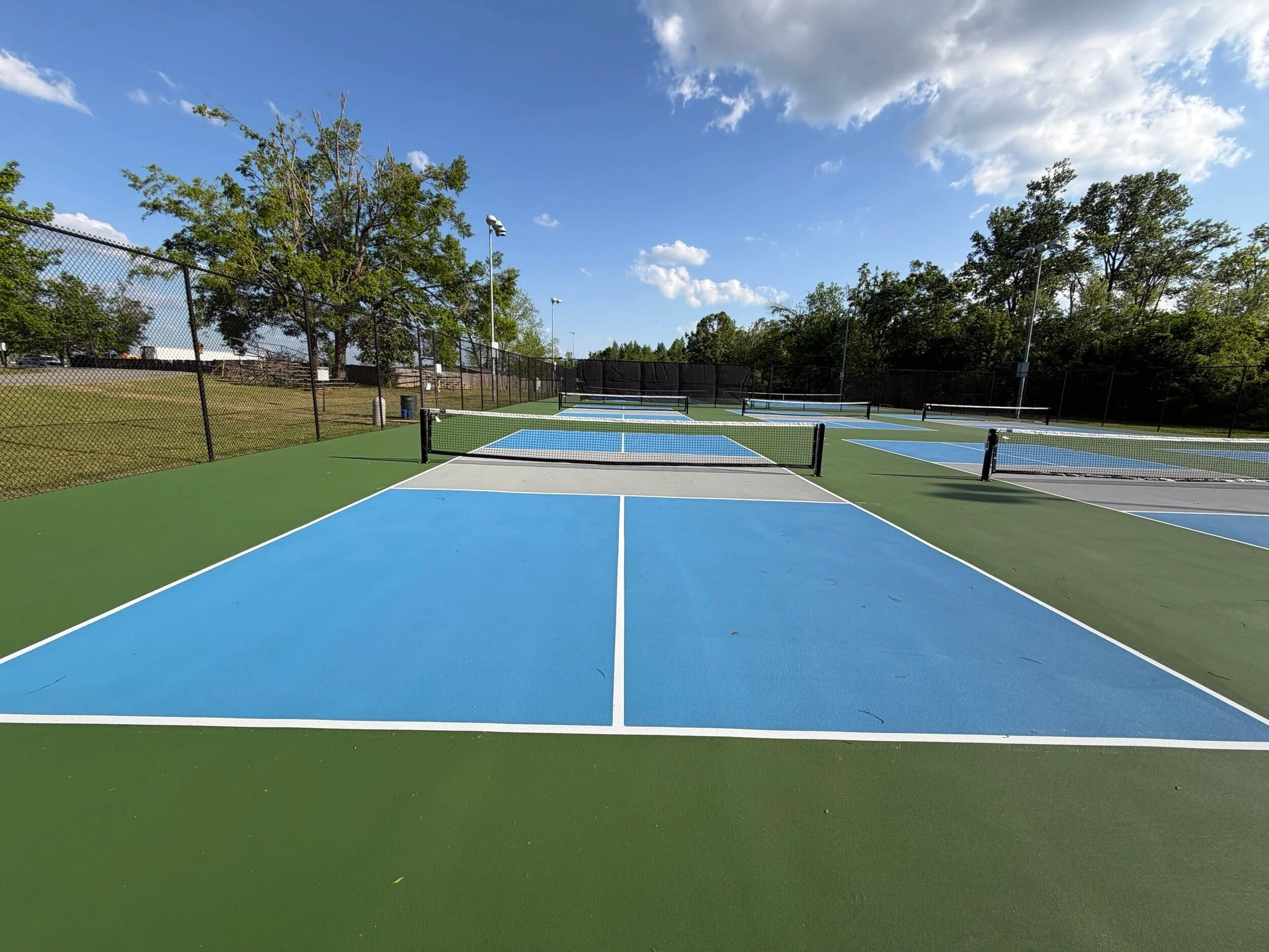Multiple resurfaced pickleball courts with new nets and crisp white game lines at Corinth Parks & Rec